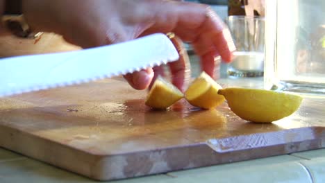 A-woman-slices-a-lemon-on-a-wooden-cutting-board