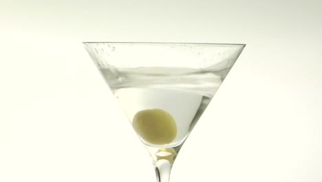 A-green-olive-is-dropped-into-a-martini