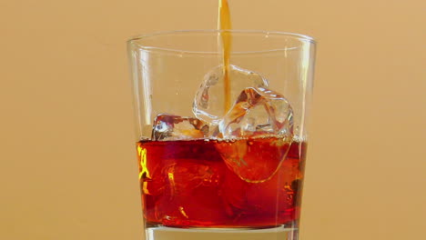 Liquor-is-poured-into-a-glass-with-ice