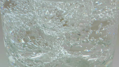 A-slow-vertical-pan-of-glass-containing-ice-and-sparkling-water