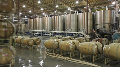 A-cellar-crew-tops-off-wine-barrels