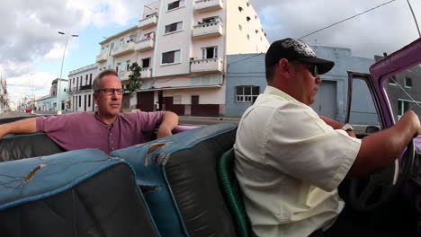 A-man-rides-in-a-convertible-classic-car-in-Havana-Cuba