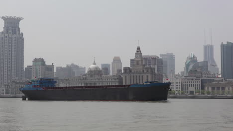 The-smoggy-skyline-of-Shanghai-China-with-river-traffic-foreground-1