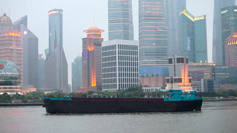 The-dusk-skyline-of-Shanghai-China-with-river-traffic-foreground-and-boats-passing