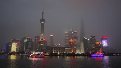 The-night-skyline-of-Shanghai-China-with-river-traffic-foreground-and-boats-passing