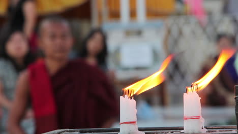 A-Burmese-monk-prays-at-a-Buddhist-temple-with-candles-foreground-1