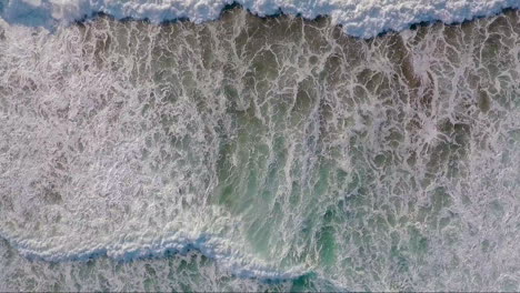 An-very-good-aerial-perspective-looking-straight-down-at-the-ocean-with-waves-rolling-in