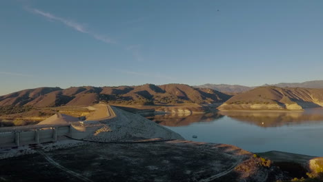 Aerial-rising-over-a-dry-lake-and-dam-in-California-during-drought