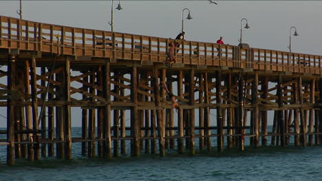 Young-men-jump-from-a-pier-into-the-sea
