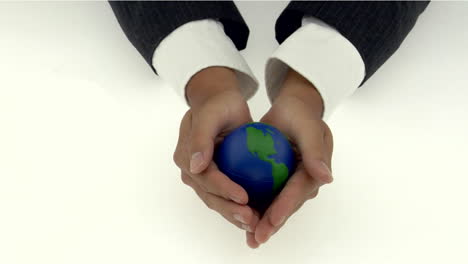 A-pair-of-cupped-hands-holds-a-small-globe
