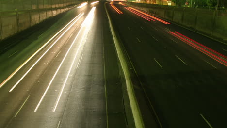 A-slow-tilt-up-reveals-traffic-move-at-light-speed-along-a-freeway-in-this-time-lapse-shot