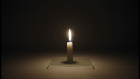 Timelapse-of-a-small-candle-burning-in-a-dark-room