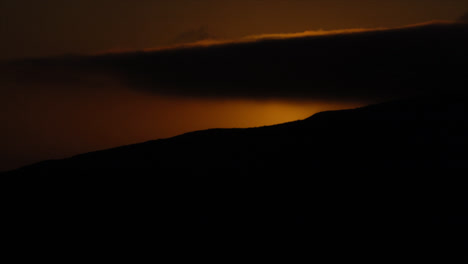 Time-lapse-of-sun-disappearing-behind-mountain-top-at-sunset