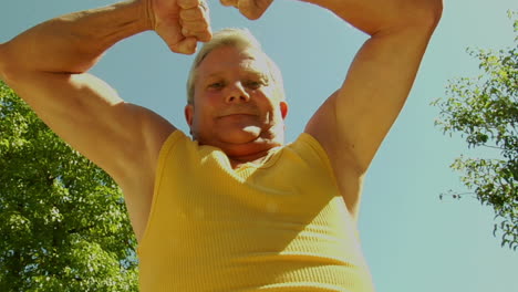 An-older-man-flexes-his-muscles
