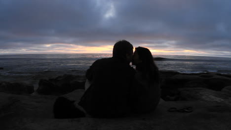 A-couple-kiss-on-a-beach-just-after-sunset-