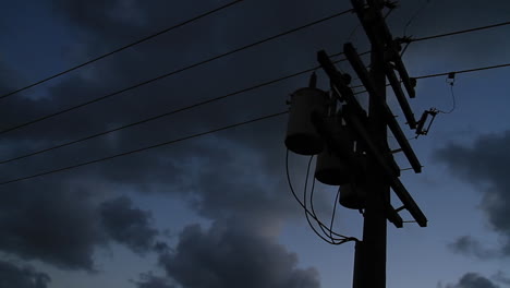Power-lines-silhouetted-against-a-dark-sky-