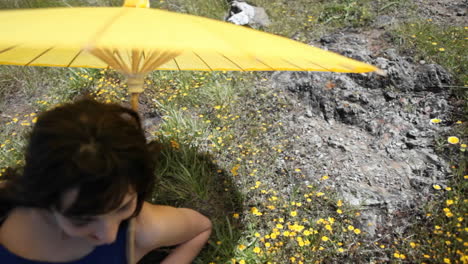 A-woman-with-an-umbrella-is-lying-in-a-field