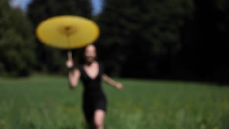 A-woman-with-an-umbrella-runs-through-a-field
