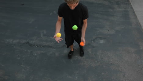 A-man-does-a-juggling-act-in-the-street-with-three-colored-balls
