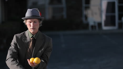 A-man-does-a-juggling-act-using-three-orange-balls
