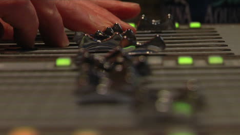 Fingers-push-sliders-on-a-sound-board