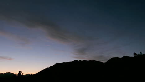 Clouds-move-over-a-silhouetted-mountain-during-golden-hour