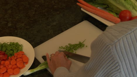 A-woman-chops-green-onions-on-a-cutting-board