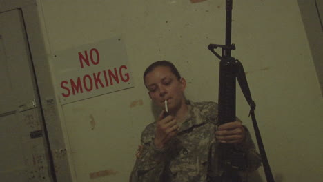 Un-Soldado-Enciende-Un-Cigarrillo-Frente-A-Un-Letrero-De-No-Humo