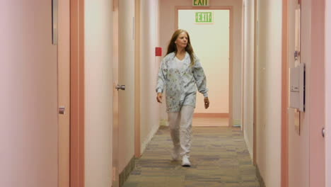 A-medical-professional-walks-down-the-hallway-of-a-medical-facility