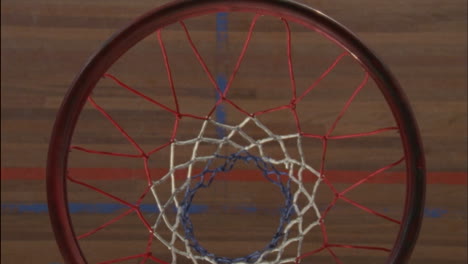 A-man-tosses-a-basketball-through-a-hoop-and-picks-it-up-when-it-bounces