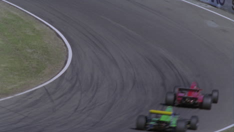 Three-cars-race-around-a-track