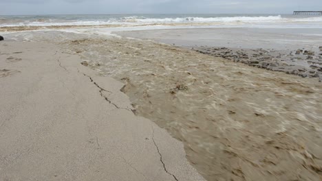 Sanjon-Creek-washing-beach-sand-into-the-ocean-after-heavy-rain-in-Ventura-California