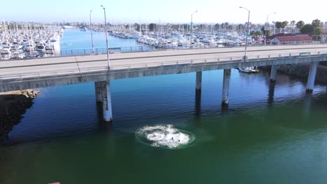 Aerial-Over-Three-Young-Men-Who-Jump-Into-Oxnard-Harbor-From-A-Bridge-California
