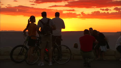 Tourists-On-Bicycles-Pause-At-The-Rim-Of-The-Grand-Canyon-At-Sunset