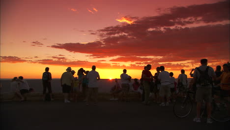 Touristen-Machen-Bei-Sonnenuntergang-Eine-Pause-Am-Rand-Des-Grand-Canyon