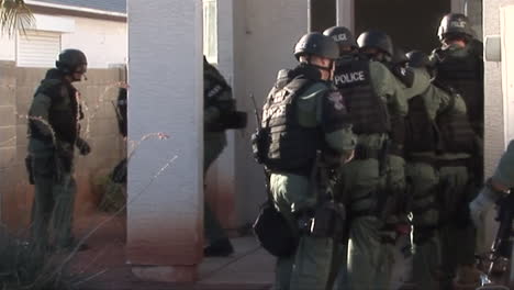 A-Swat-Team-Raids-A-Suspected-Drug-House-With-Flash-Grenades-And-Guns-Drawn