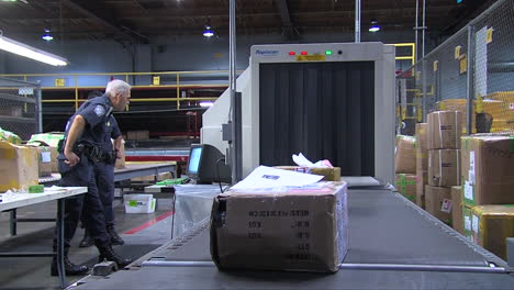 Homeland-Security-Agents-Inspect-Packages-In-A-Shipping-Facility