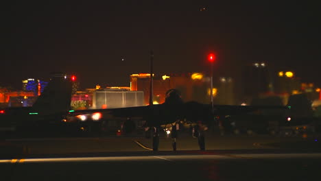 F15-Kampfjets-Taxis-Auf-Einer-Landebahn-In-Der-Nacht-Gegen-Die-Skyline-Von-Las-Vegas