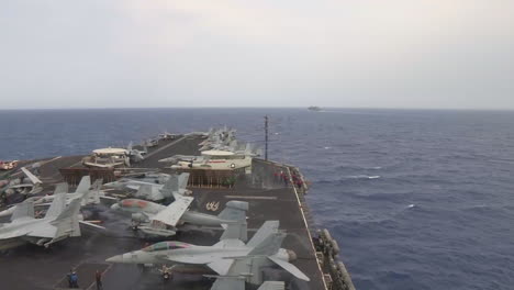 High-Angle-Shot-Across-The-Deck-Of-An-Aircraft-Carrier-At-Sea