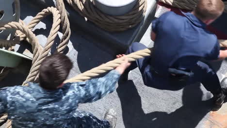 Sailors-Aboard-A-Navy-Ship-Haul-Ropes-On-The-Deck-Of-A-Warship