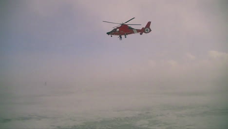 An-Airman-Descends-From-A-Coast-Guard-Search-And-Rescue-Helicopter-In-A-Blizzard-1