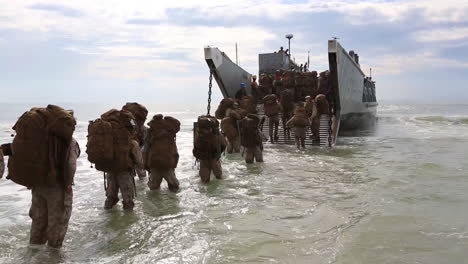 Troops-Wade-Through-Ocean-Waves-To-Board-An-Amphibious-Transport-Vehicle