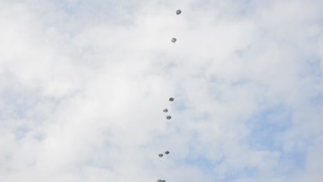 Ground-Angle-View-Of-Paratroopers-Parachuting-To-Earth-From-A-C17-3