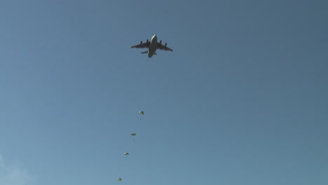 Ground-Angle-View-Of-Paratroopers-Parachuting-To-Earth-From-A-C17-4