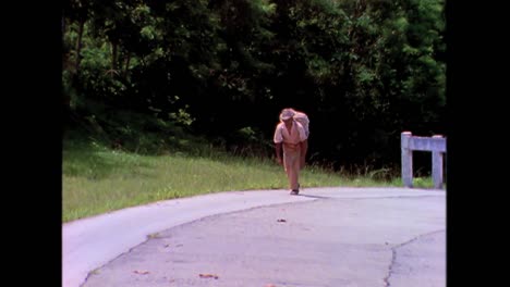 An-old-man-carries-tobacco-along-a-road-in-the-1980s