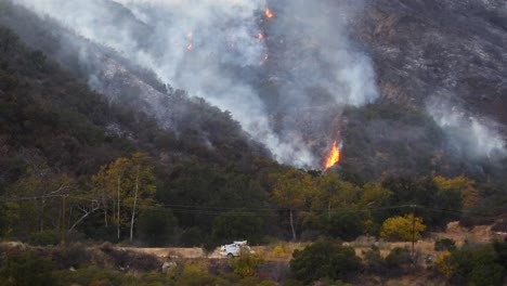 The-Thomas-Fire-Burns-In-The-Hills-And-Brush-Above-Ojai-California-With-A-Southern-California-Edison-Truck-Passing-Foreground