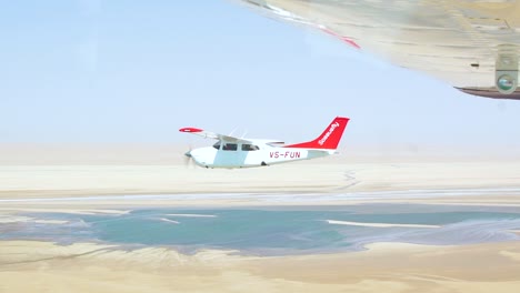 Zeitlupe-Luft-zu-Luft-Aufnahme-Eines-Leichten-Flugzeugs,-Das-über-Die-Namib-Wüstenskelettküste-Namibias-Fliegt