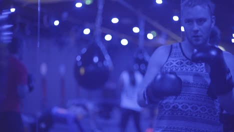 A-Boxer-Works-Out-With-A-Punching-Bag-In-A-Blue-Neon-Lit-Gym