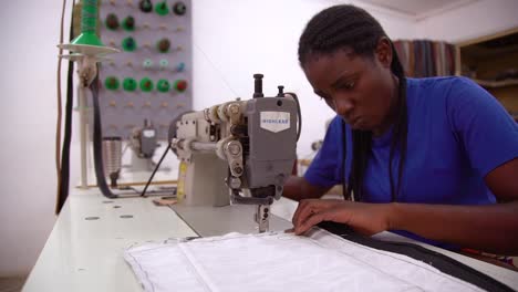 A-Woman-Worker-Sews-A-Garment-By-Hand-In-A-Sweatshop-In-Zambia-Africa