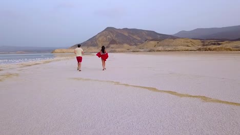 Ein-Mann-Und-Eine-Frau-Laufen-Auf-Einem-Salzsee-Oder-Strand-In-Dschibuti-Afrika
